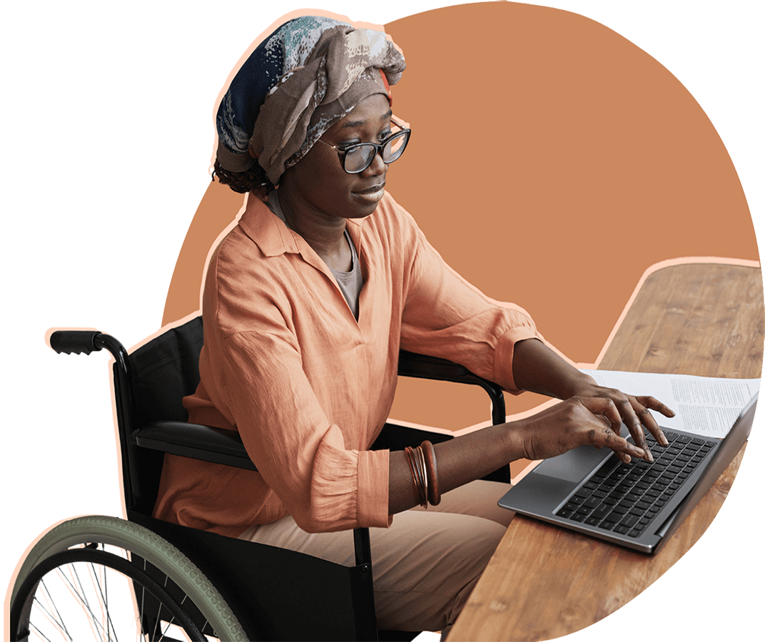 Side view of a person in a wheelchair working at their desk.