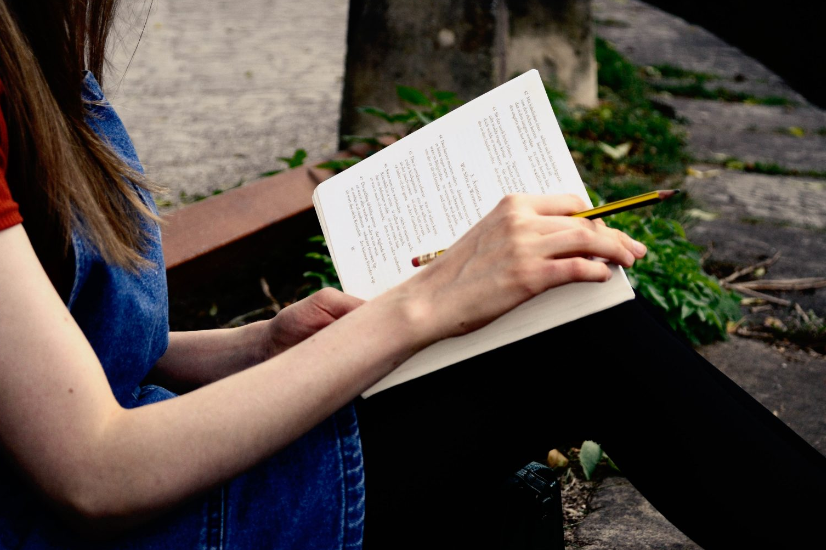 Jennifer studying and reading her book outside